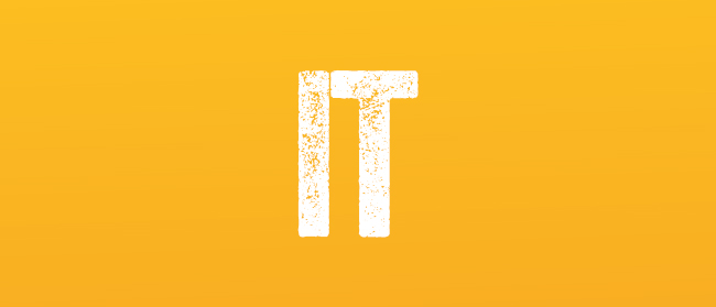 Das Wort IT steht in fetten, weißen, leicht abgenutzten Großbuchstaben auf einem soliden orangefarbenen Hintergrund.