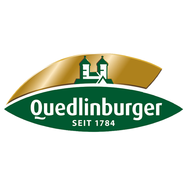 Logo mit zwei Kirchtürmen in Weiß auf goldenem Hintergrund über dem grünen Schriftzug „Quedlinburger SEIT 1784“ in einem grünen Oval.