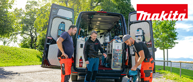Drei Männer in Arbeitskleidung stehen an einem sonnigen Tag neben einem offenen Lieferwagen, der mit Werkzeugen und Ausrüstung gefüllt ist. Zwei untersuchen ein Elektrowerkzeug, während der dritte zusieht. Das Makita-Logo ist in der oberen rechten Ecke zu sehen.